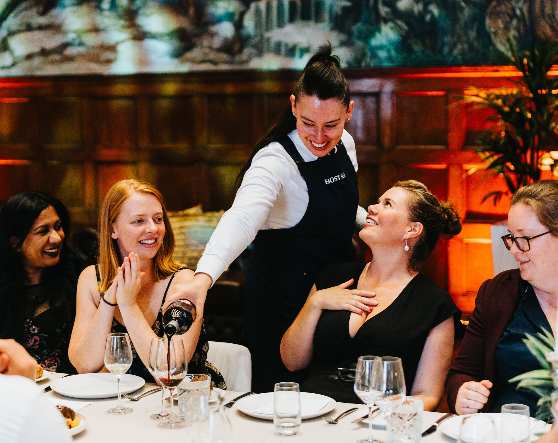 staff serving wine at a Gala dinner in a big dining hall room