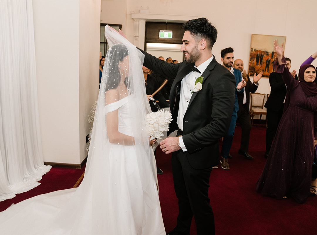 Groom excitedly lifting the bride's veil at the Chancellor's Room, Holme Building 