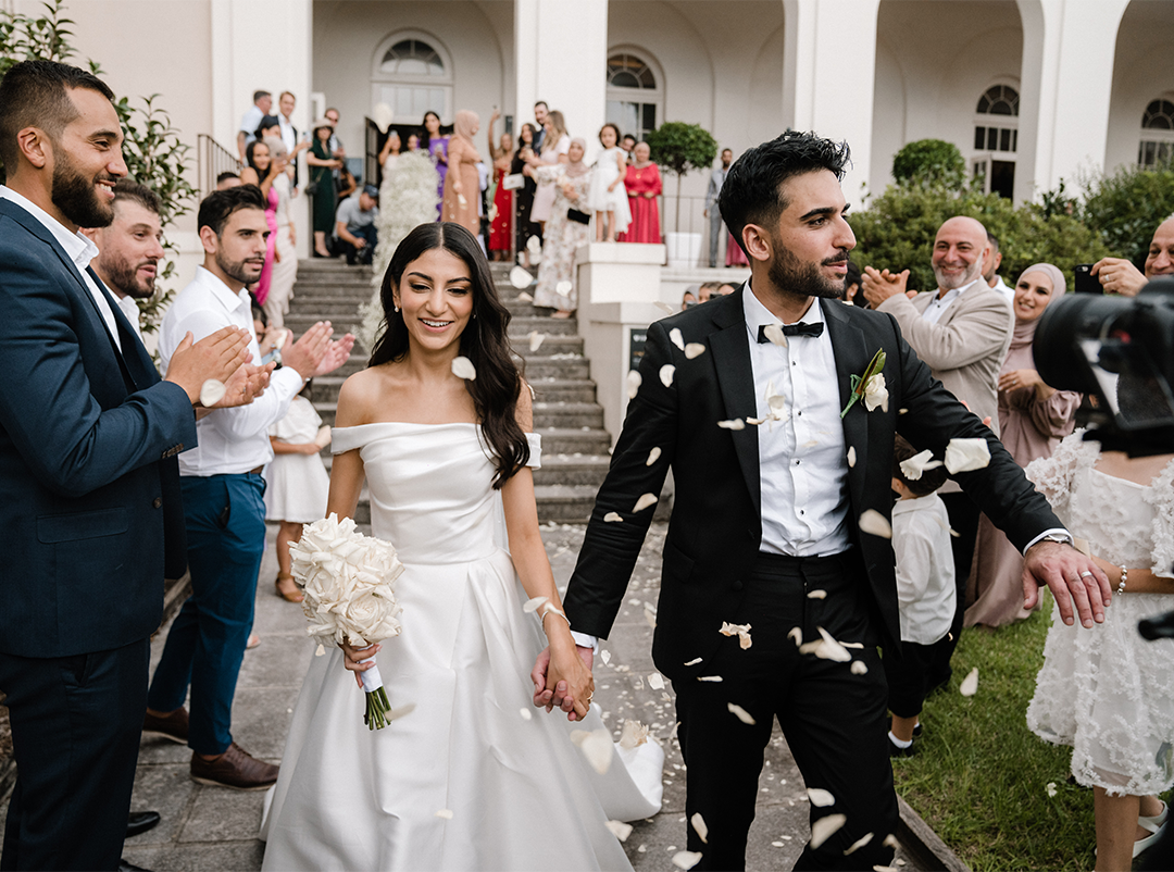 Couple gracefully walking out of the Holme Building during the wedding recessional 