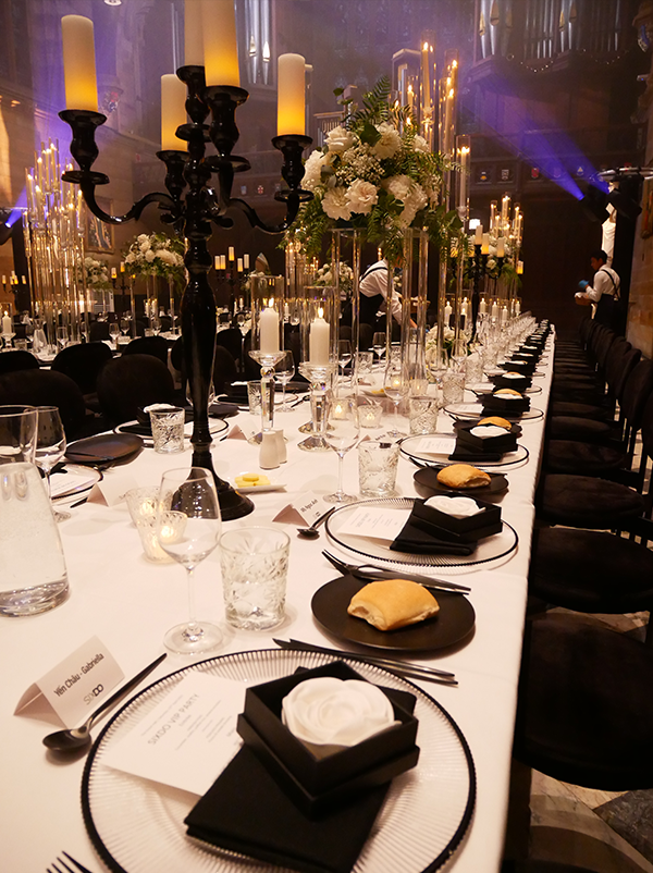 HostCo front-of-house staff setting up tables for SIXDO's dinner event at the University of Sydney's Great Hall